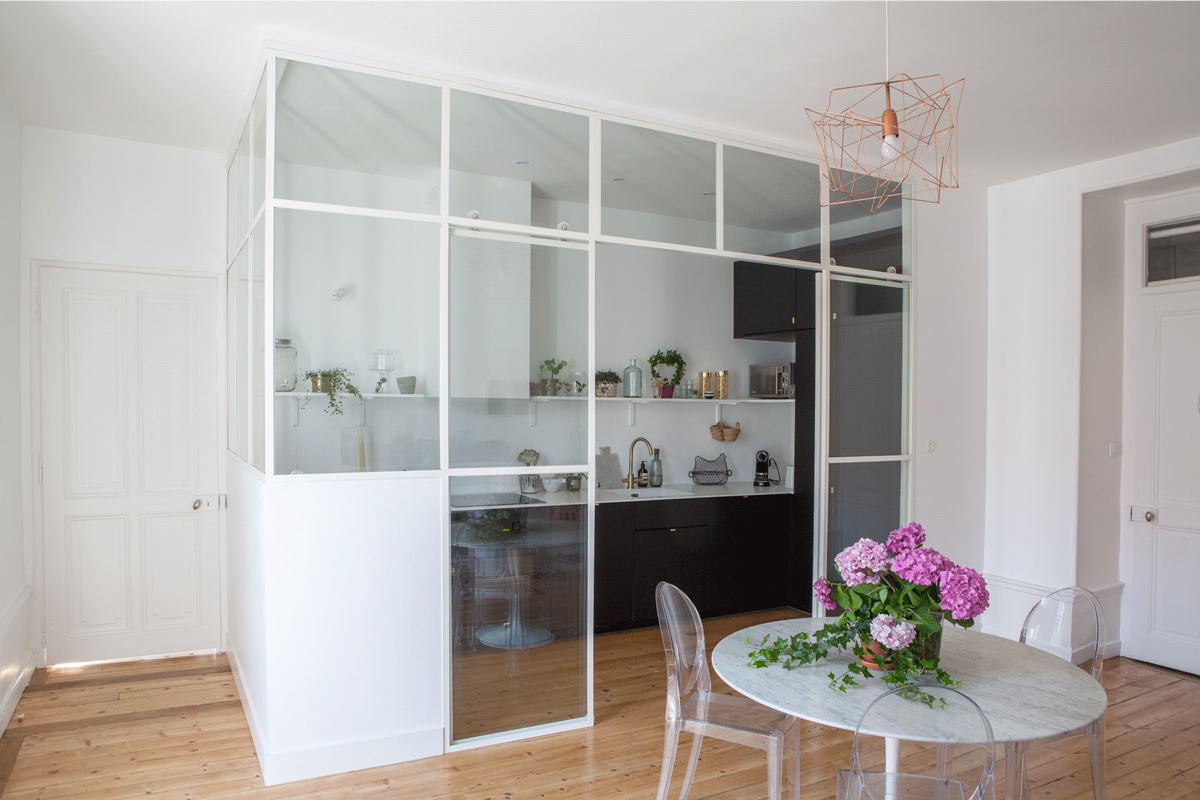 Vue sur la table de la cuisine et cuisine en fond dans Verrière..